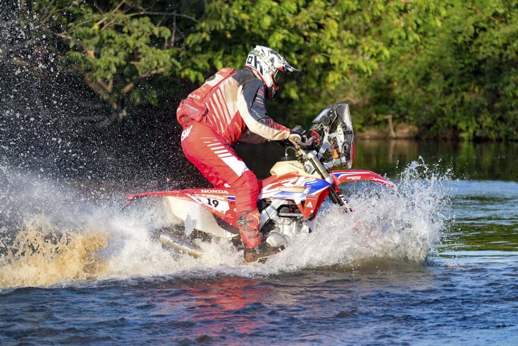 O piloto Gabriel Soares atravessa um rio pilotando sua CRF 450RX